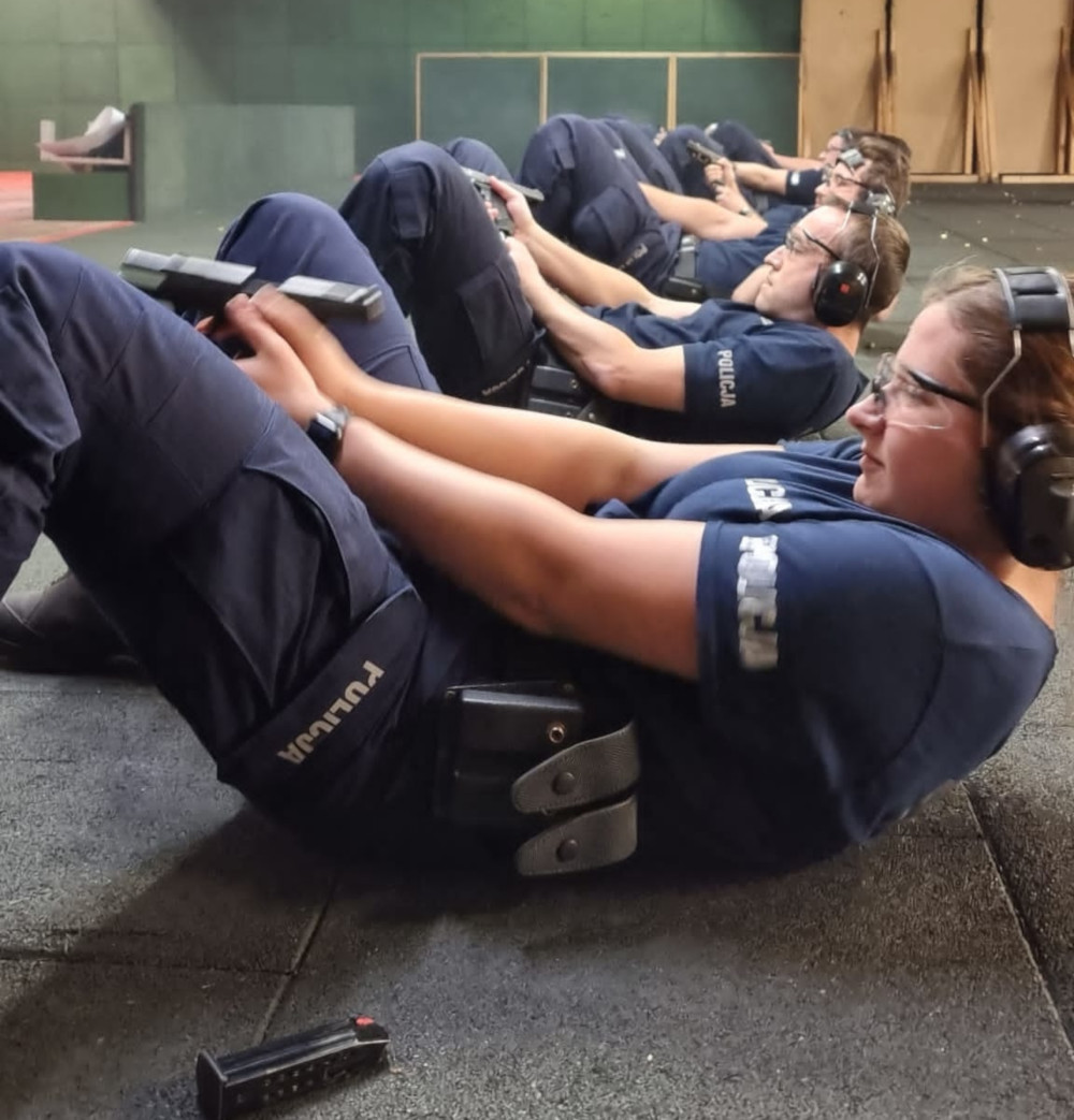 Policjanci podczas treningu strzeleckiego w pozycji leżącej.