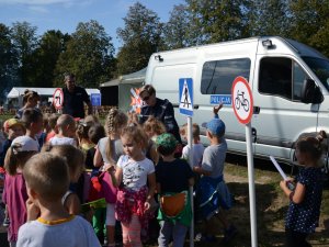 Wykładowcy Zakładu Ruchu Drogowego oraz Służby Prewencyjnej prezentują dzieciom stoisko profilaktyczne podczas pikniku z okazji 100-lecia Centrum Szkolenia Łączności i Informatyki w Zegrzu.