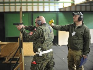 Funkcjonariusze rywalizują w konkurencji strzeleckiej. Każdy uczestnik ma za zadanie pokonać dystans 100 m z przeszkodami, po czym oddać po 10 strzałów do tarczy zamieszczonej w odległości 15 m z postawy stojącej oraz klęczącej