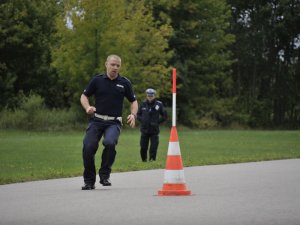 Zawodnicy konkursu Policjant Ruchu Drogowego podczas zadania umiejętności jazdy samochodem. Tor Centrum Szkolenia Policji w Legionowie.