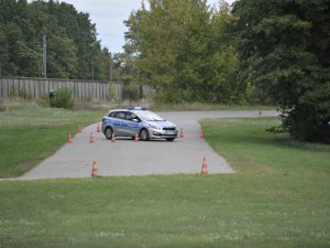 Zawodnicy konkursu Policjant Ruchu Drogowego podczas zadania umiejętności jazdy samochodem. Tor Centrum Szkolenia Policji w Legionowie.