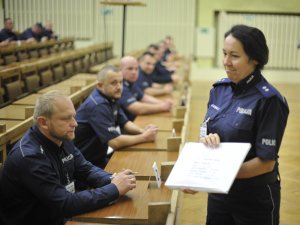 Uczestnicy konkursu Policjant Ruchu Drogowego podczas pisania testu sprawdzającego umiejętności w zakresie udzielania pomocy ofiarom wypadków komunikacyjnych. Aula Centrum Szkolenia Policji.