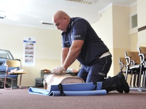 Uczestnicy konkursu Policjant Ruchu Drogowego w trakcie testu praktycznego umiejętności w zakresie udzielania pomocy ofiarom wypadków komunikacyjnych.