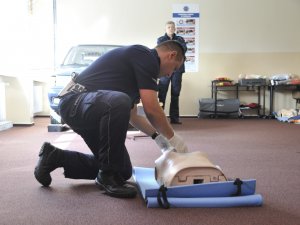 Uczestnicy konkursu Policjant Ruchu Drogowego w trakcie testu praktycznego umiejętności w zakresie udzielania pomocy ofiarom wypadków komunikacyjnych.