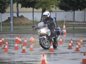 Zawodnicy konkursu Policjant Ruchu Drogowego pokonują tor na motocyklu służbowym. Plac apelowy Centrum Szkolenia Policji.