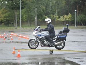 Zawodnicy konkursu Policjant Ruchu Drogowego pokonują tor na motocyklu służbowym. Plac apelowy Centrum Szkolenia Policji.