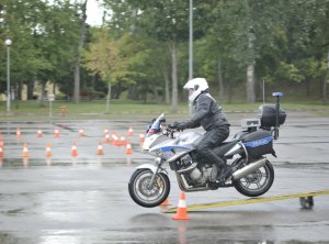 Zawodnicy konkursu Policjant Ruchu Drogowego pokonują tor na motocyklu służbowym. Plac apelowy Centrum Szkolenia Policji.