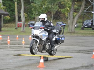 Zawodnicy konkursu Policjant Ruchu Drogowego pokonują tor na motocyklu służbowym. Plac apelowy Centrum Szkolenia Policji.