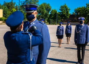 Komendant CSP przypina odznakę Zasłużony Policjant