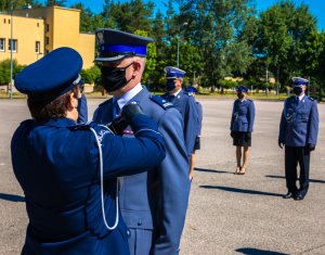 Komendant CSP przypina odznakę Zasłużony Policjant