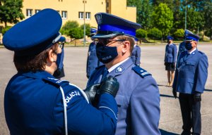 Komendant CSP przypina odznakę Zasłużony Policjant