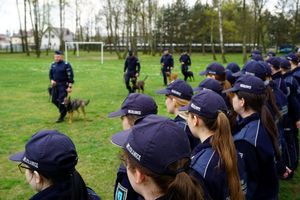 Uczniowie klasy mundurowej w trakcie zajęć z policjantami oraz w trakcie pokazu umiejętności psów służbowych.